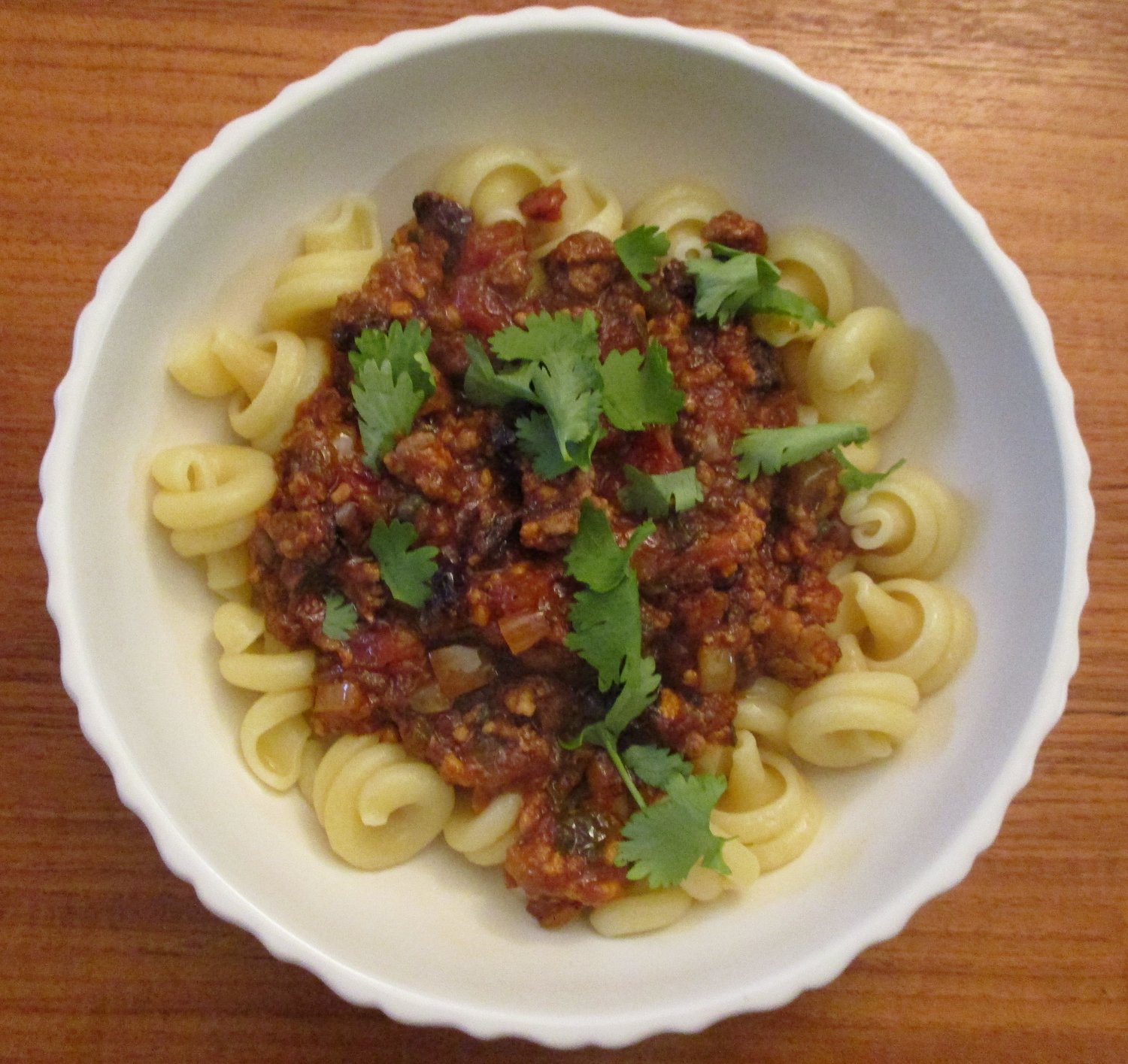 Picadillo, ground meat cooked in a delicious sweet-sour mix of flavors, is shown here over pasta.